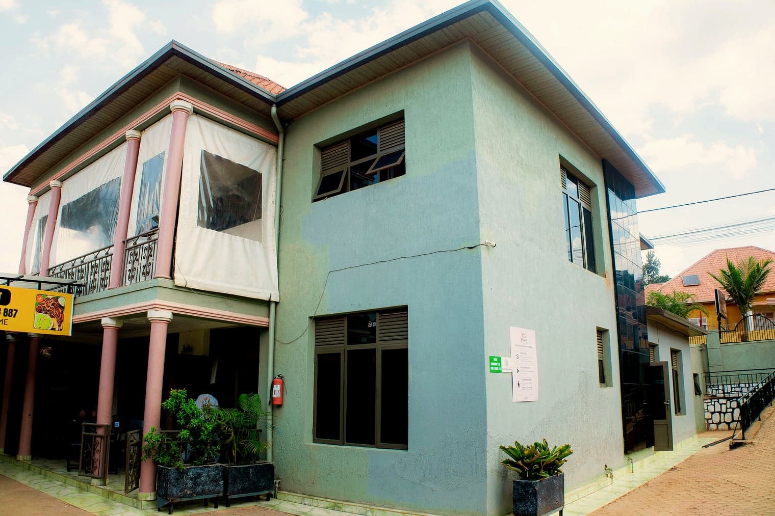 The two-storey guest house with its balcony and potted plants along the courtyard
